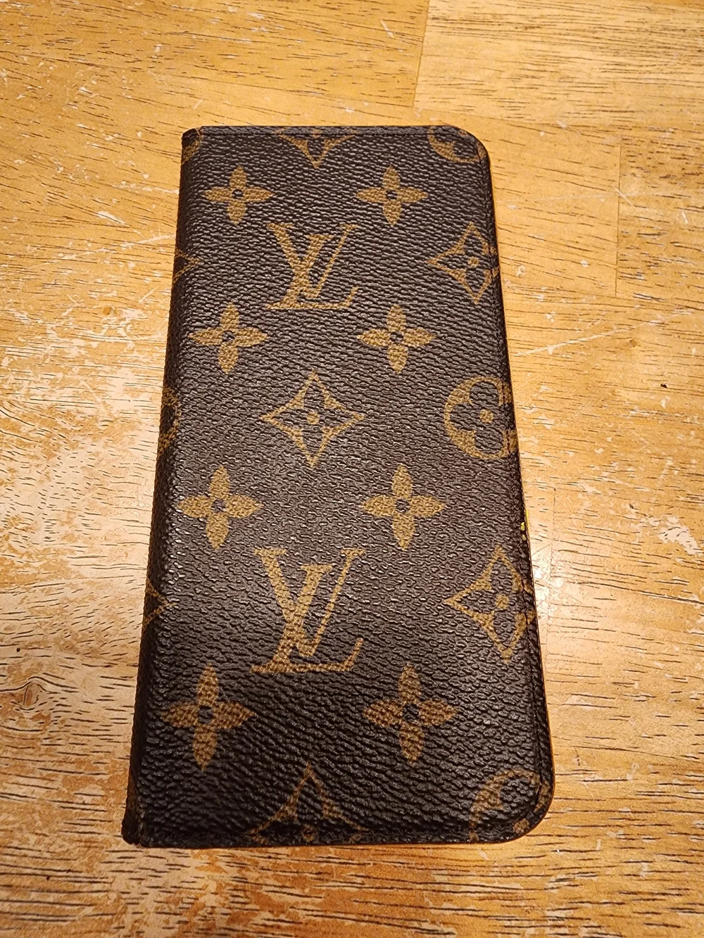 Louis Vuitton Monogram iPhone Folio Case crafted in the brand's signature brown